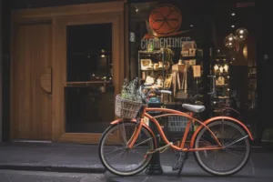 a bike parked near a shop with the front wheel have lock wrapped around the nearby piller
